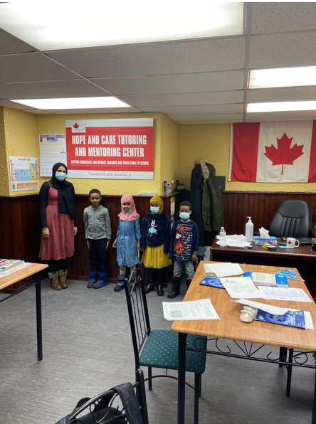 Tutor standing with a group of young students at the learning centre
