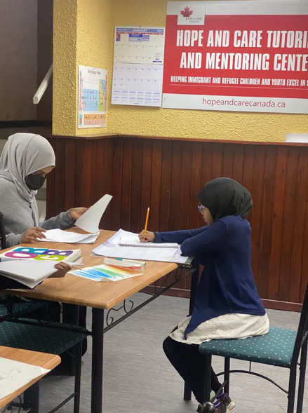 Tutor and young student working together at a classroom table