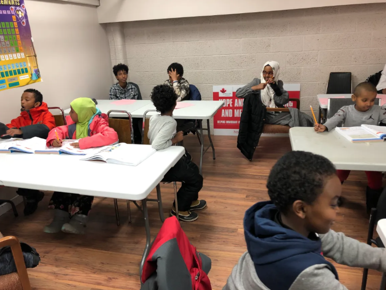 Children studying together around classroom tables at the tutoring centre