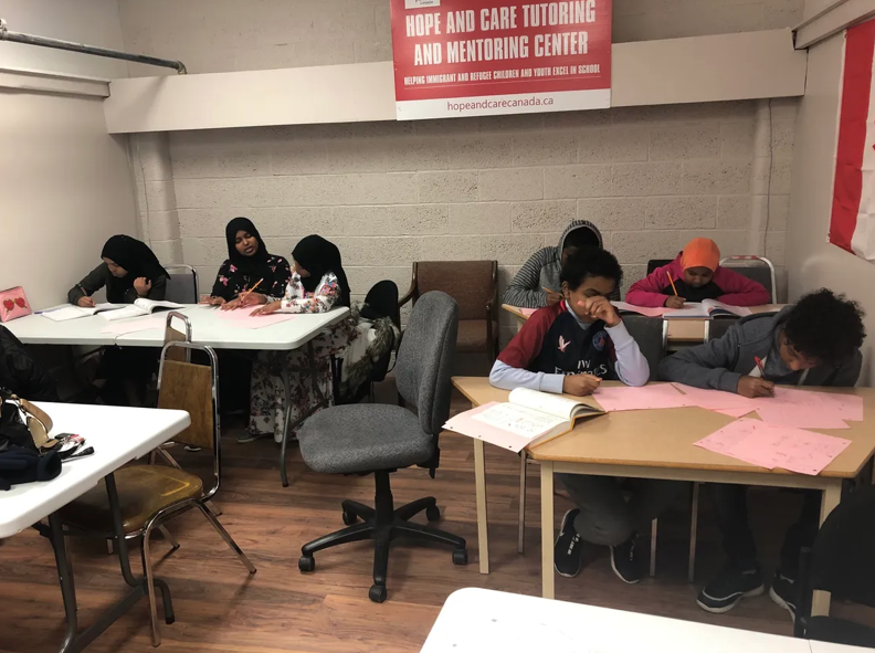 Children and volunteer mentors working on classroom activities