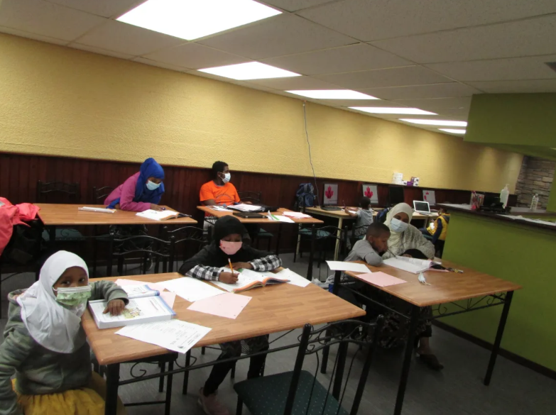 Students completing assignments around tables in the tutoring centre